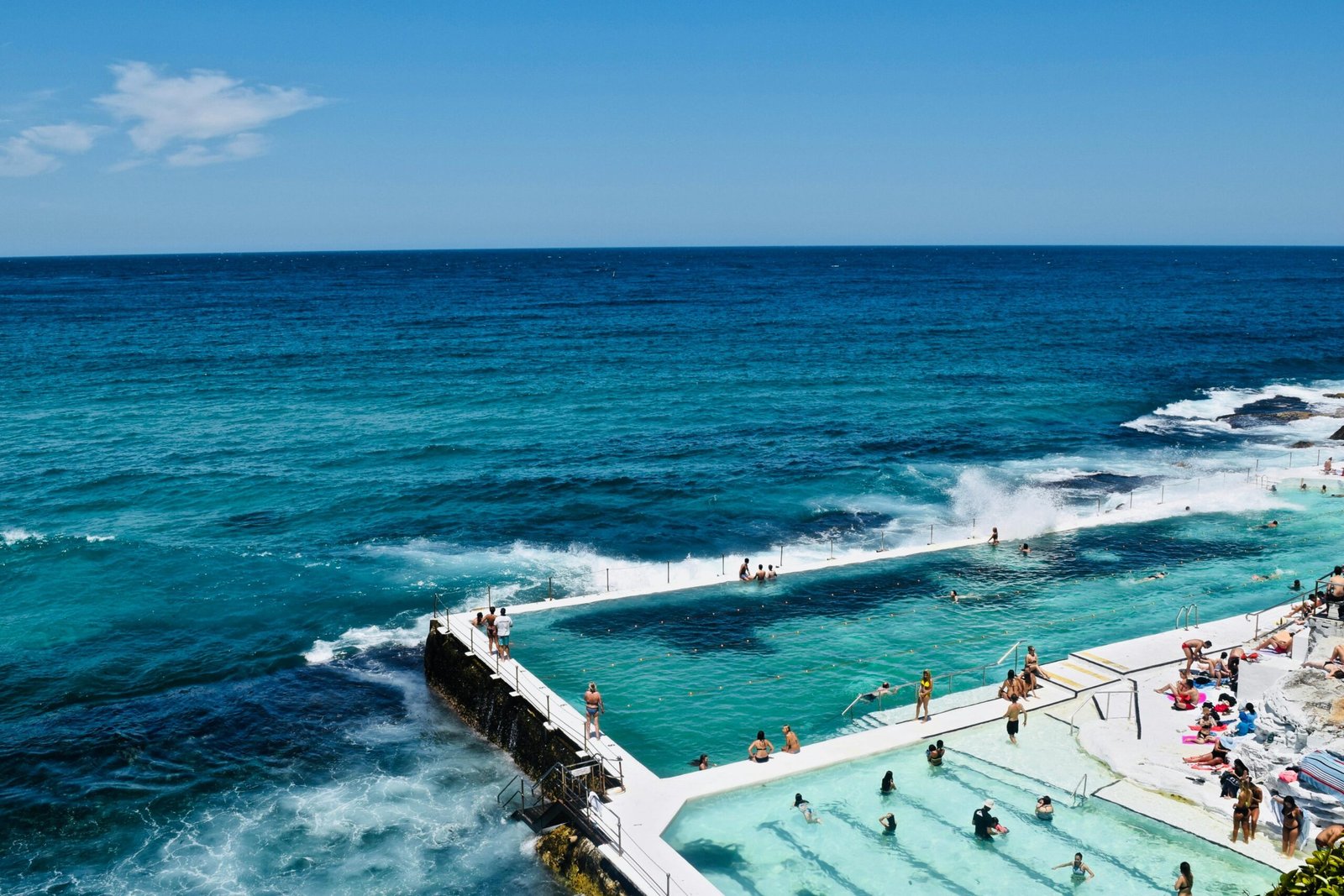 A vibrant scene at Bondi Beach ocean pool with swimmers enjoying the sun and waves.